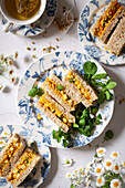 Plates of finger sandwiches filled with coronation chicken.