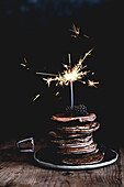 Stack of tasty chocolate pancakes with fresh blackberries and sparkler