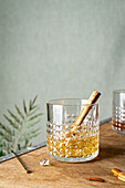 Whiskey mit Zimtstange serviert im Kristallglas
