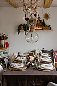 Weihnachtlich gedeckter Tisch mit Tischset aus Bast und weißen Tellern