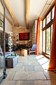 View of seating area in open plan living room with stone tiles, and patio door