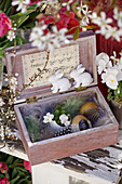 Wooden box with Easter eggs, horned violets and feathers as Easter decoration