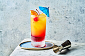 Tequila Sunrise in a glass with a cocktail umbrella