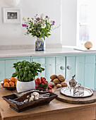 Basil, tomatoes, and cutlery on a kitchen table