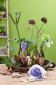 Mariendistel, Echinops, Lavendel, Enzian und Hortensie in Vasen