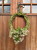 Autumn wreath with hops and clematis as door decoration