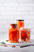 Homemade sweet pickled red peppers in a jar