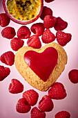 A heart-shaped biscuit with passion fruit and raspberries