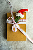 Geschenkkarton mit Weihnachtsmütze auf Betonuntergrund