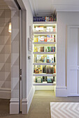 Illuminated niche bookshelf in a hallway with a sliding door