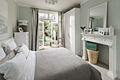 Classic bedroom in grey and white with fireplace console