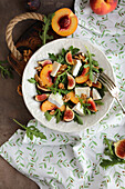 A light salad with rocket, peaches and brie cheese
