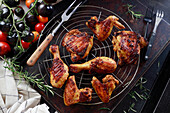 Grilled chicken drumsticks, thighs, and wings on a grill rack