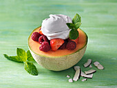 Melon filled with berries and whipped cream