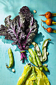 An arrangement of purple cabbage leaves, yellow beets and broad beans