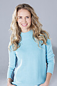 Blonde Frau in hellblauem Pullover