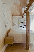 Sleeping area with queen bed, rustic wooden support in the foreground