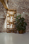 Vintage room divider and houseplant in front of brick wall