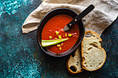 Tomato soup with fresh cerely sticks served on stone table