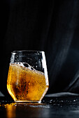 Ein Glas Bier vor schwarzem Hintergrund