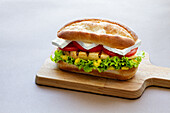 Sandwich mit Hähnchen, Salatblatt, Tomate und Käse
