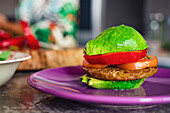 Avocado-Burger mit veganem Patty und Tomaten