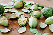 High angle of ripe and halved fresh artichokes on wooden table