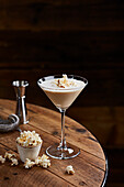 Creamy popcorn cocktail on wooden table