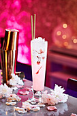 Cherry blossom cocktail in a fun colourful bar setting