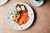 Breakfast plate with salmon, boiled eggs and rye bread