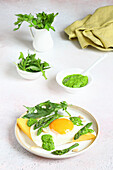 Polenta croutons with fried eggs asparagus and pesto