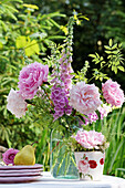 Blumenstrauß aus Pfingstrosen (Paeonia) und Fingerhut (Digitalis) auf Gartentisch