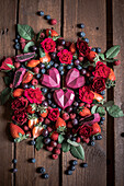 Schokoladen-Himbeer-Herzen arrangiert mit Beeren und Blüten