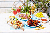 Drinks and Mediterranean grill dishes on a terrace table