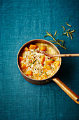 Risotto with pumpkin and rosemary in a copper pot