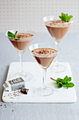 Chocolate mousse served in martini glasses with mint and grated chocolate