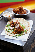 Onion butternut squash bhajis (fritters) on flatbread with mango raita and mint salad