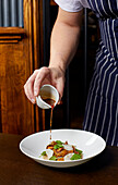 Beef cheek lasagne being drizzled with sauce