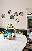 Fornasetti decorative plates hung above the bench in the dining area