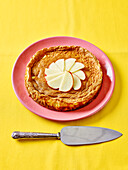 Apple cake with pink plate on yellow background