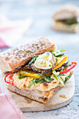 Sandwich with hummus, grilled vegetables and mixed herbs