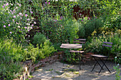 Schattiger Sitzplatz in naturnahen Garten mit Mäuerchen