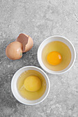 Zwei Schälchen mit aufgeschlagenen Eiern