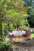 Sommerlicher, runder Tisch mit DIY-Tischdecke auf Terrassenplatz
