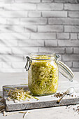 Homemade sauerkraut: Salted cabbage with caraway seeds in an iron jar
