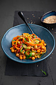 Fried vegan chickpea and vegetables with sesame seeds