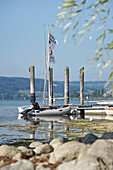 Schlauchboot, Steg und See im Sommer