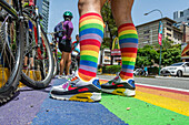 Cyclists riding on rainbow flag bike lane