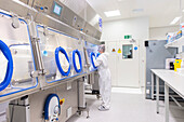 Researcher using a glovebox in a cancer research laboratory