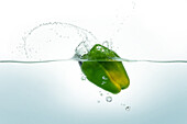 Green pepper splashing in water